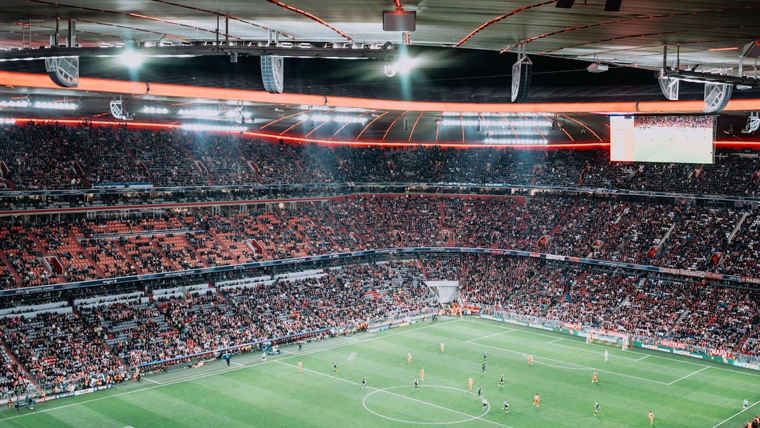 Fans fill a floodlit stadium at night for a football match, the kind of game worth traveling for during the 2026 FIFA World Cup