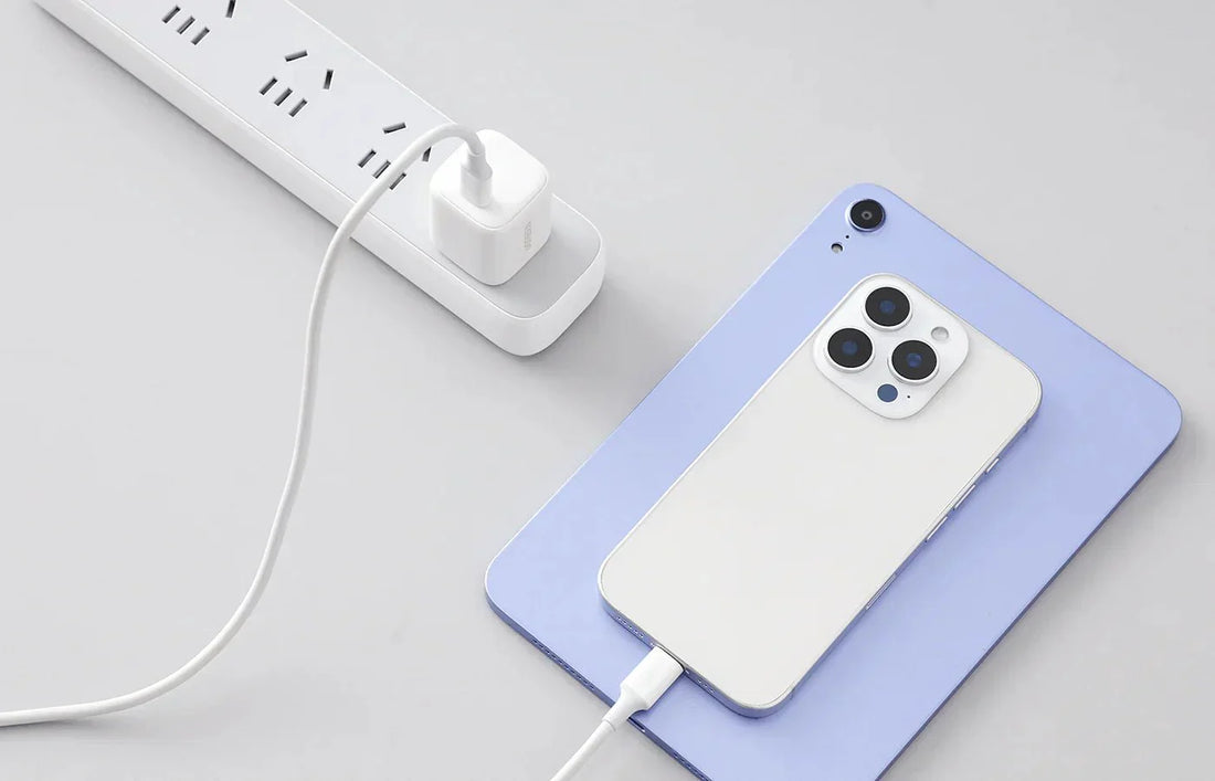 iPhone charging with a wired charger plugged into a power strip