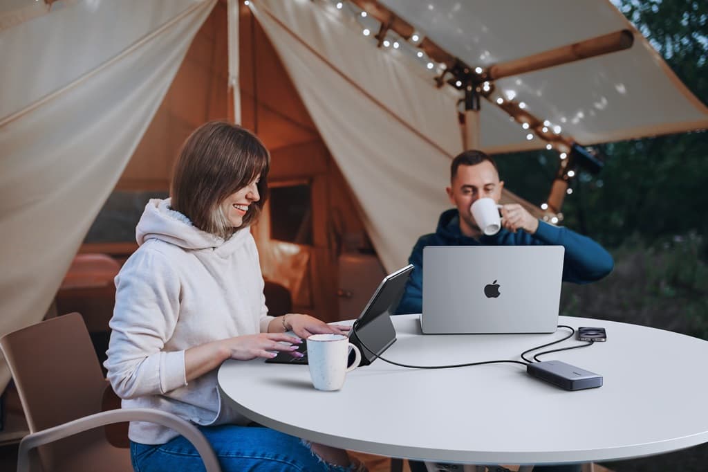 Remote work at a campsite with a laptop and portable power bank.